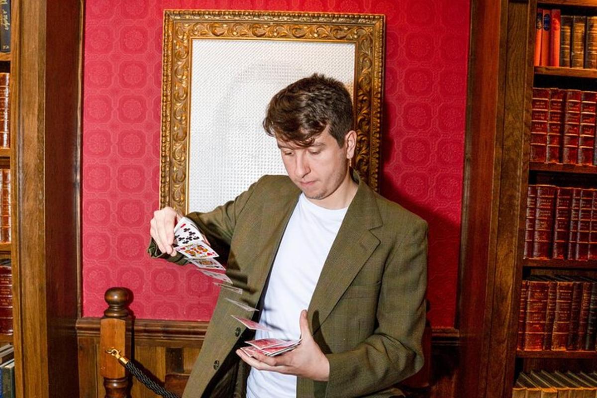 a man standing in a library looking at his cell phone
