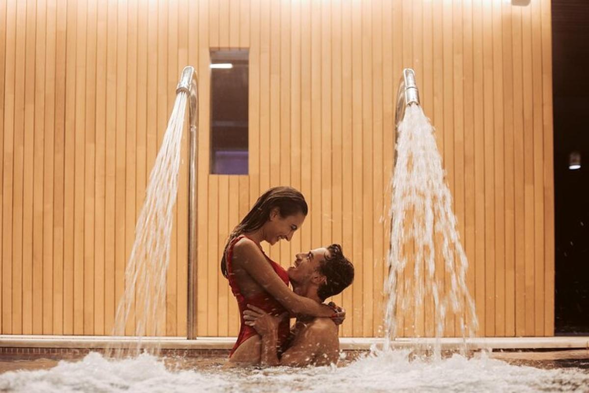 duas mulheres em pé na água de uma fonte