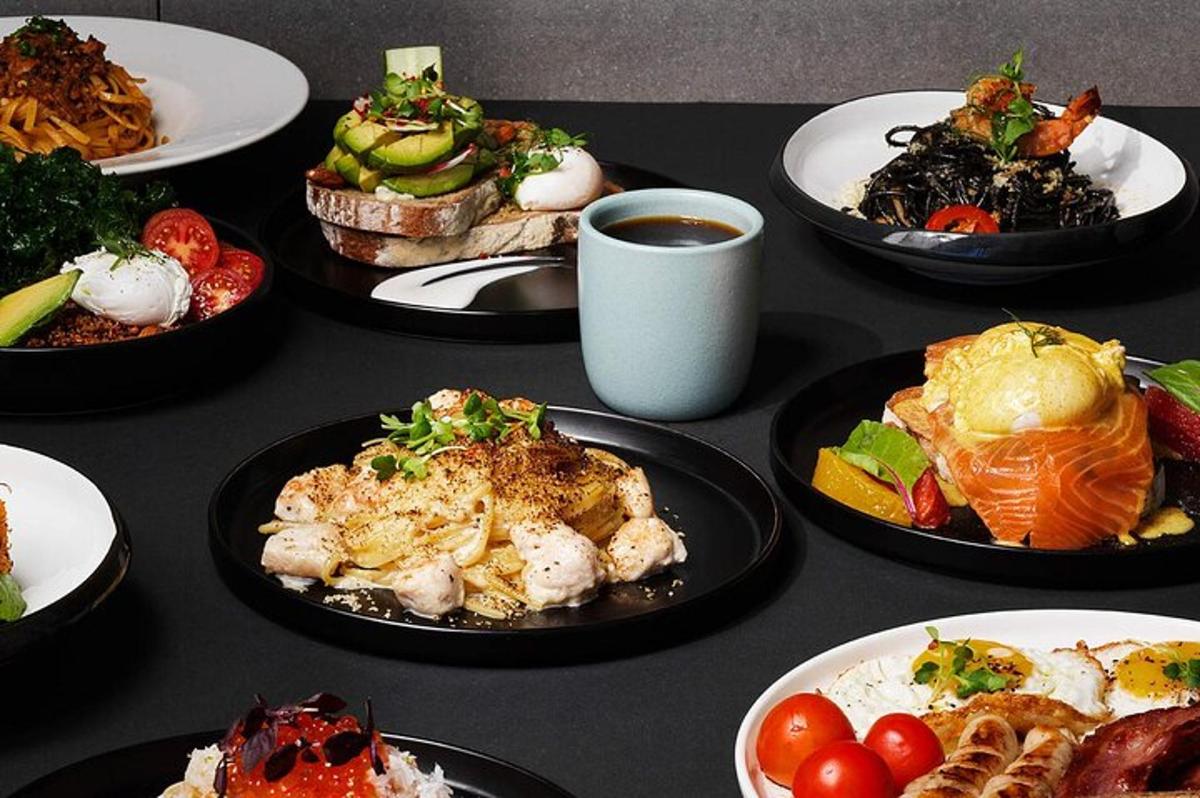 a table topped with plates of food and a cup of coffee