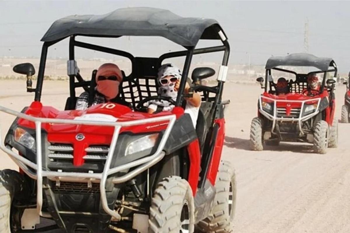 Dos personas viajando en vehículos todo terreno en el desierto