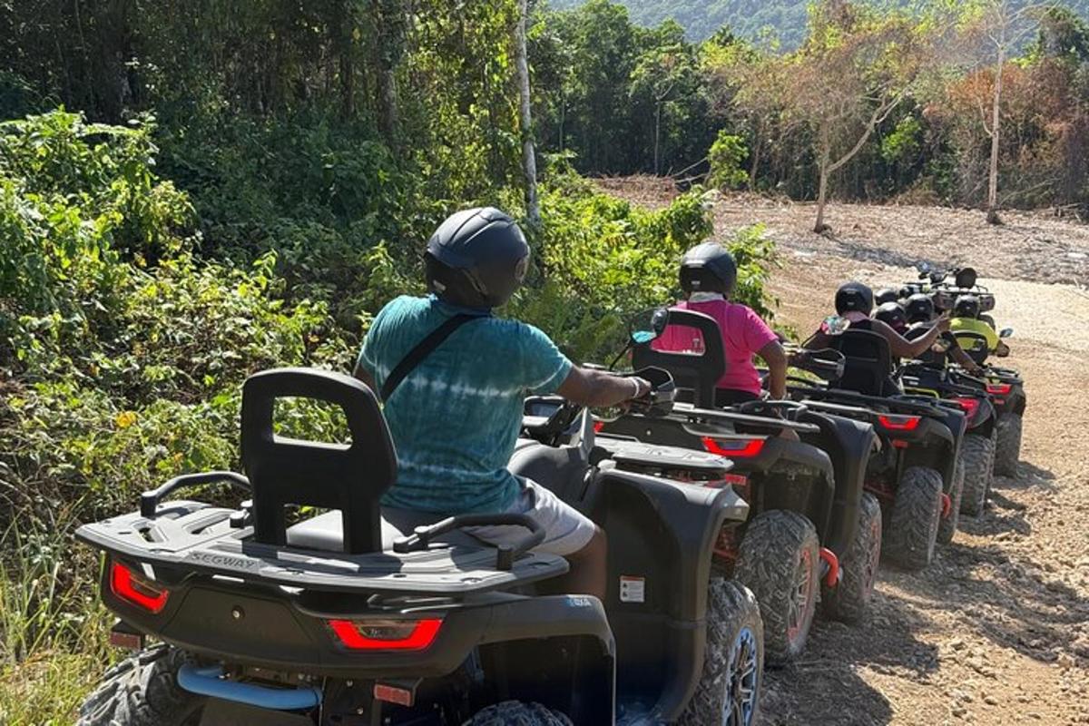 un grup de persones que condueixen quads per un camí de terra