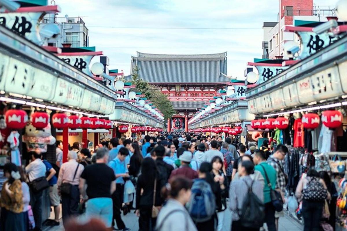 una multitud de personas caminando por un mercado lleno de gente