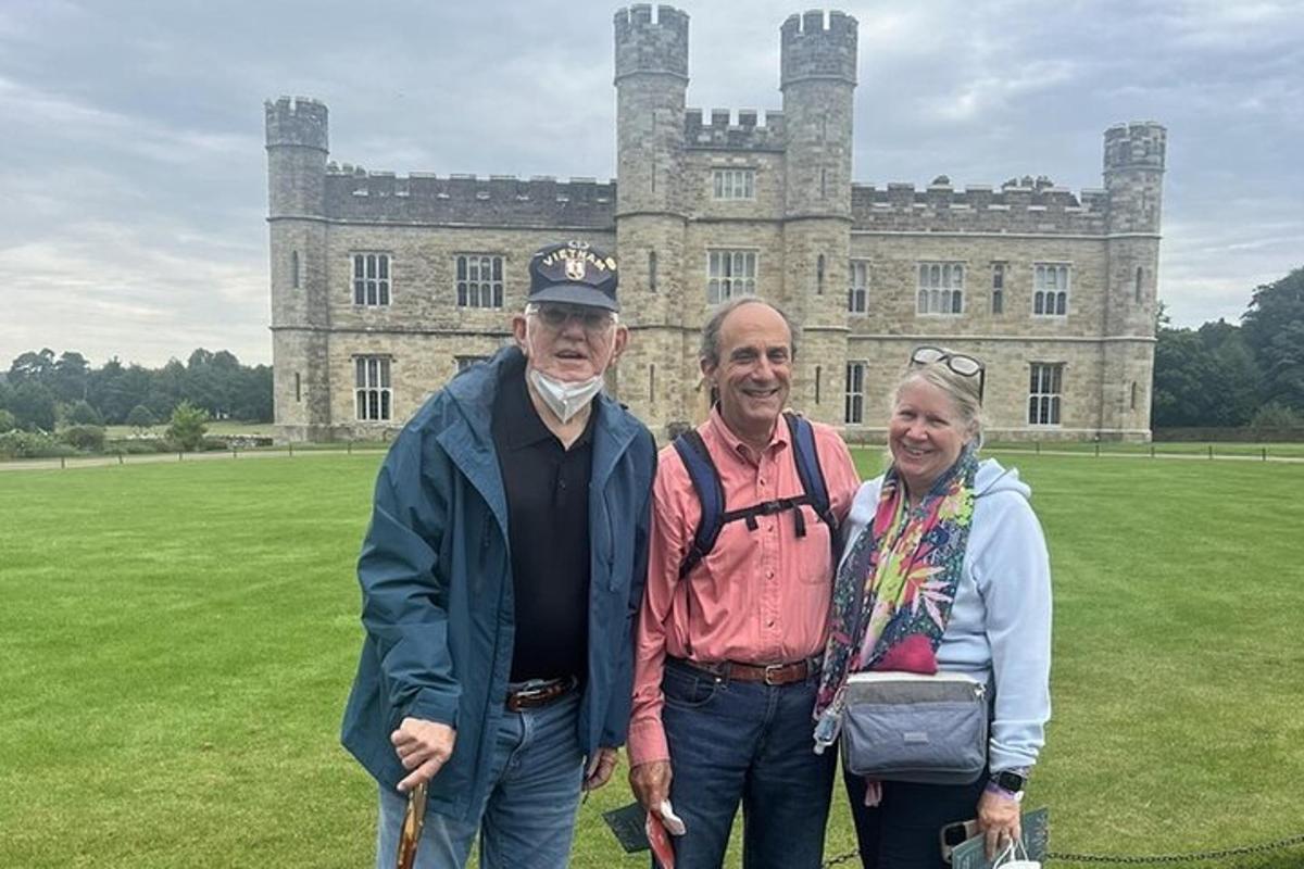 a group of three people standing in front of a castle