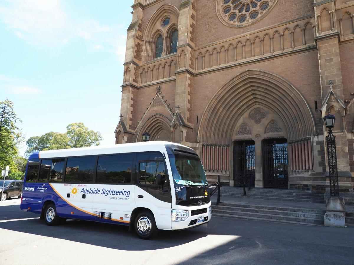 a white bus parked in front of a church
