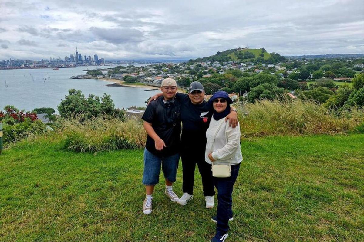a group of three people standing on top of a hill