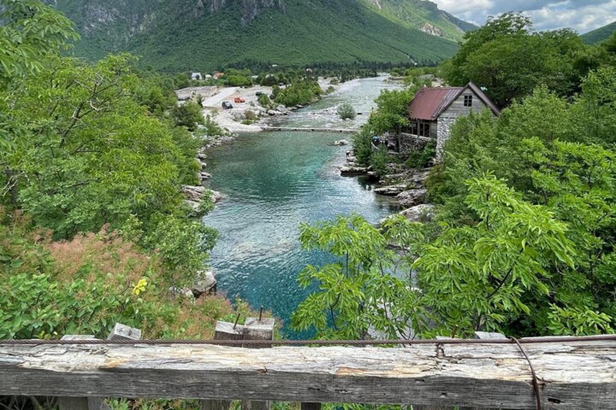 μια θέα ενός ποταμού με ένα σπίτι και ένα βουνό