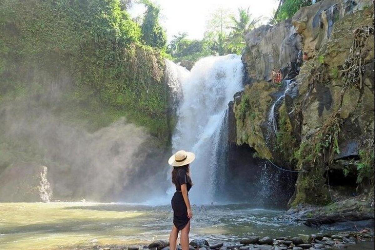 een vrouw die voor een waterval staat