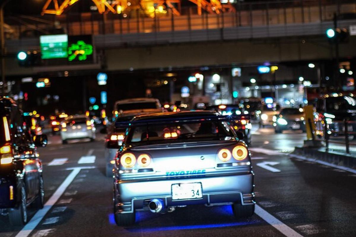 sebuah kereta lama yang memandu di jalan bandar pada waktu malam