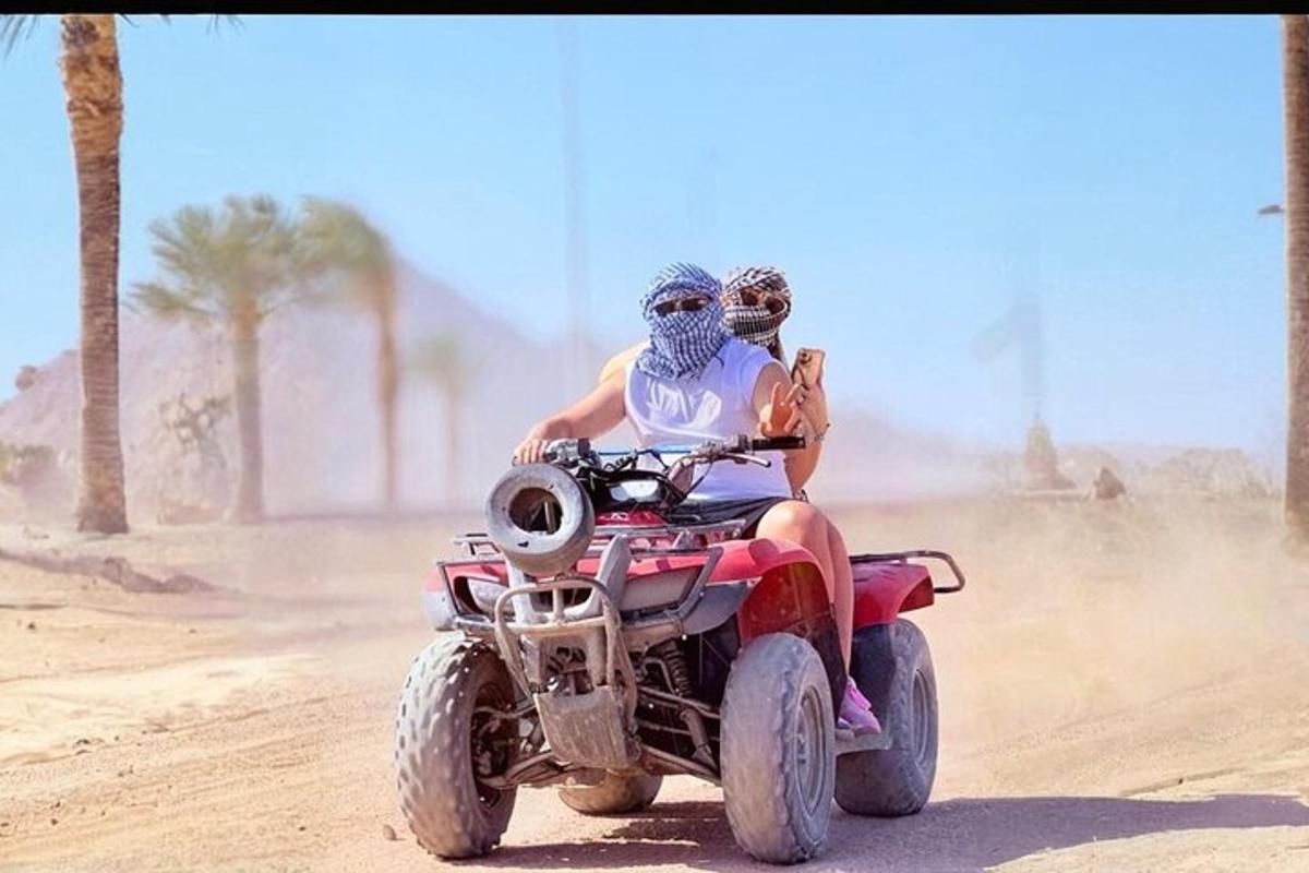 dues persones muntant un quad al desert