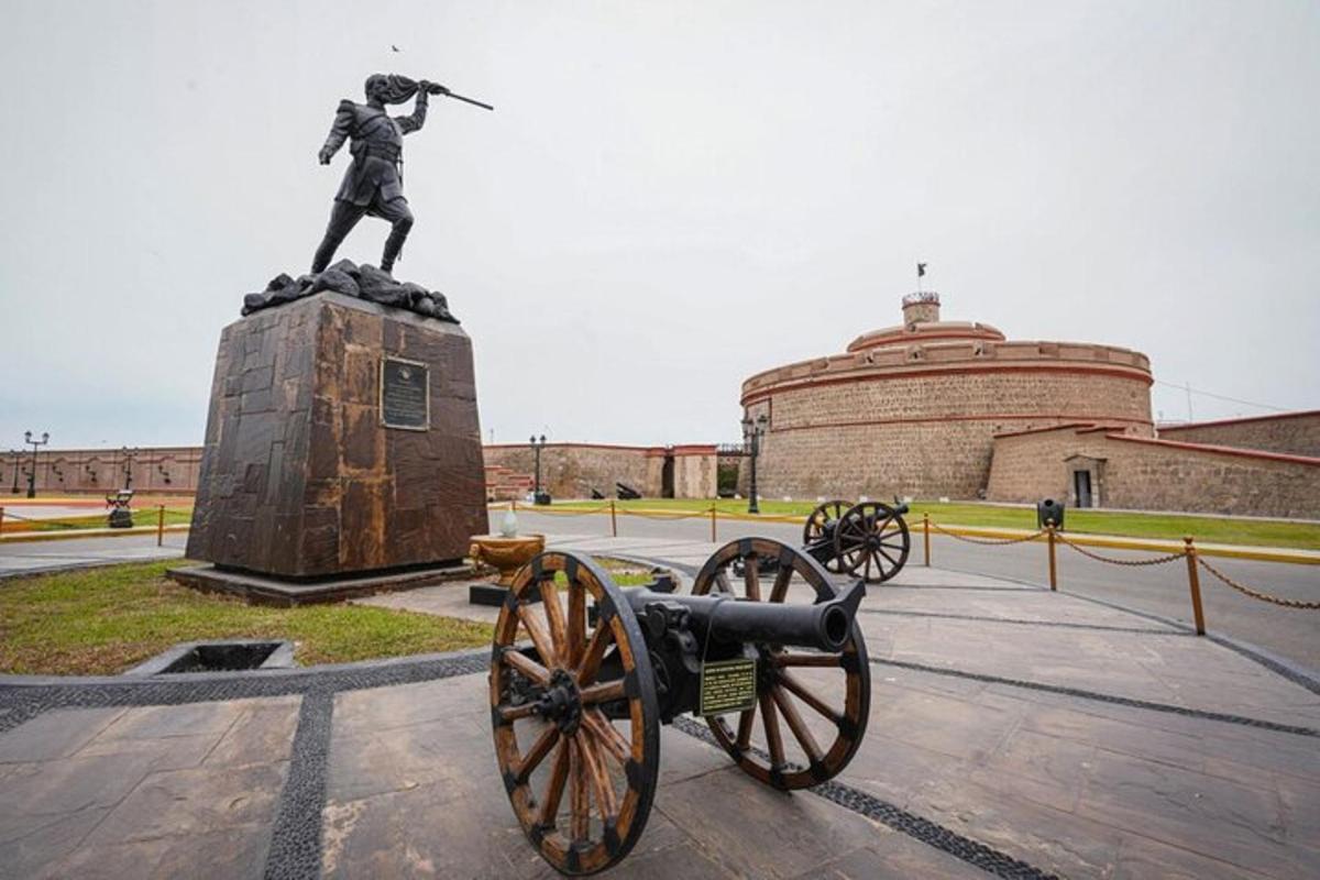 una statua di un uomo con un cannone di fronte a un edificio