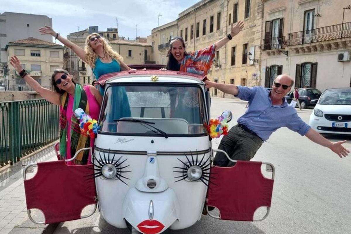 a group of people standing on the back of a car