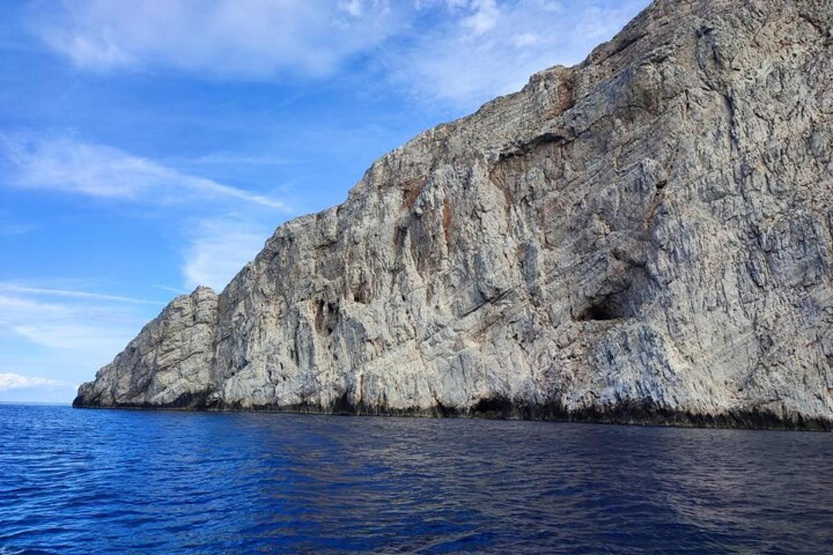 tebing berbatu besar di lautan dengan langit biru