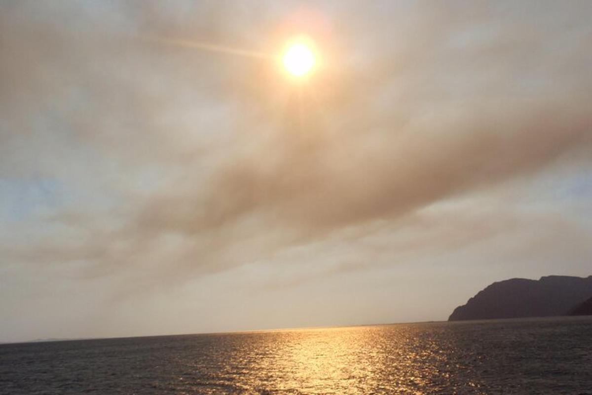 una vista de l'oceà amb el sol al cel
