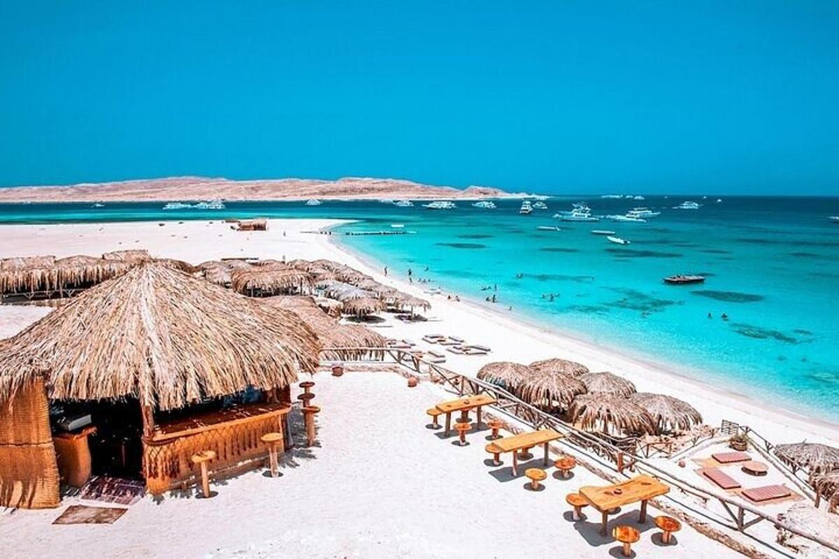 egy strand szalma napernyőkkel és székekkel, valamint az óceánnal