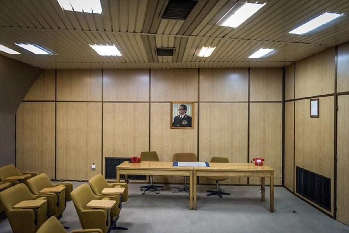 konferenční místnost s velkým dřevěným stolem a židlemi