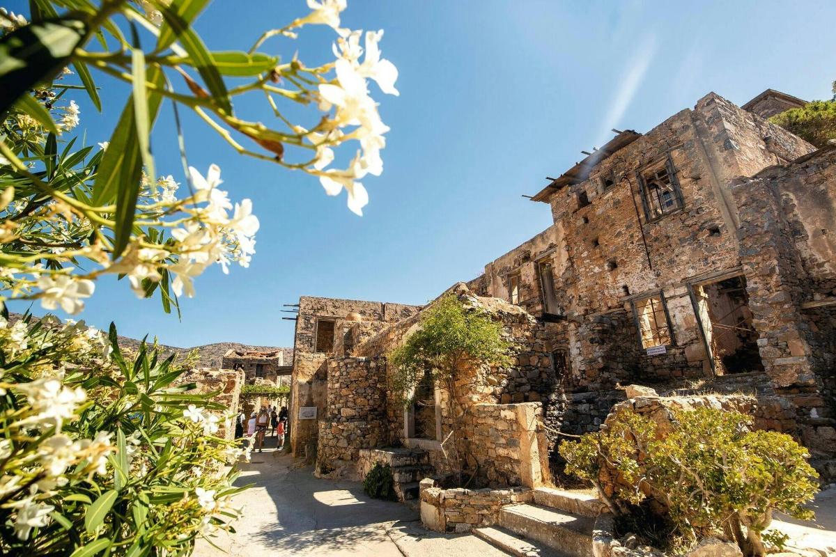 an old stone building with flowers in the foreground