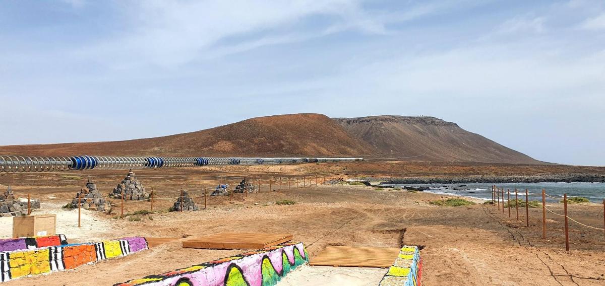 vlak jedoucí podél pláže s horou