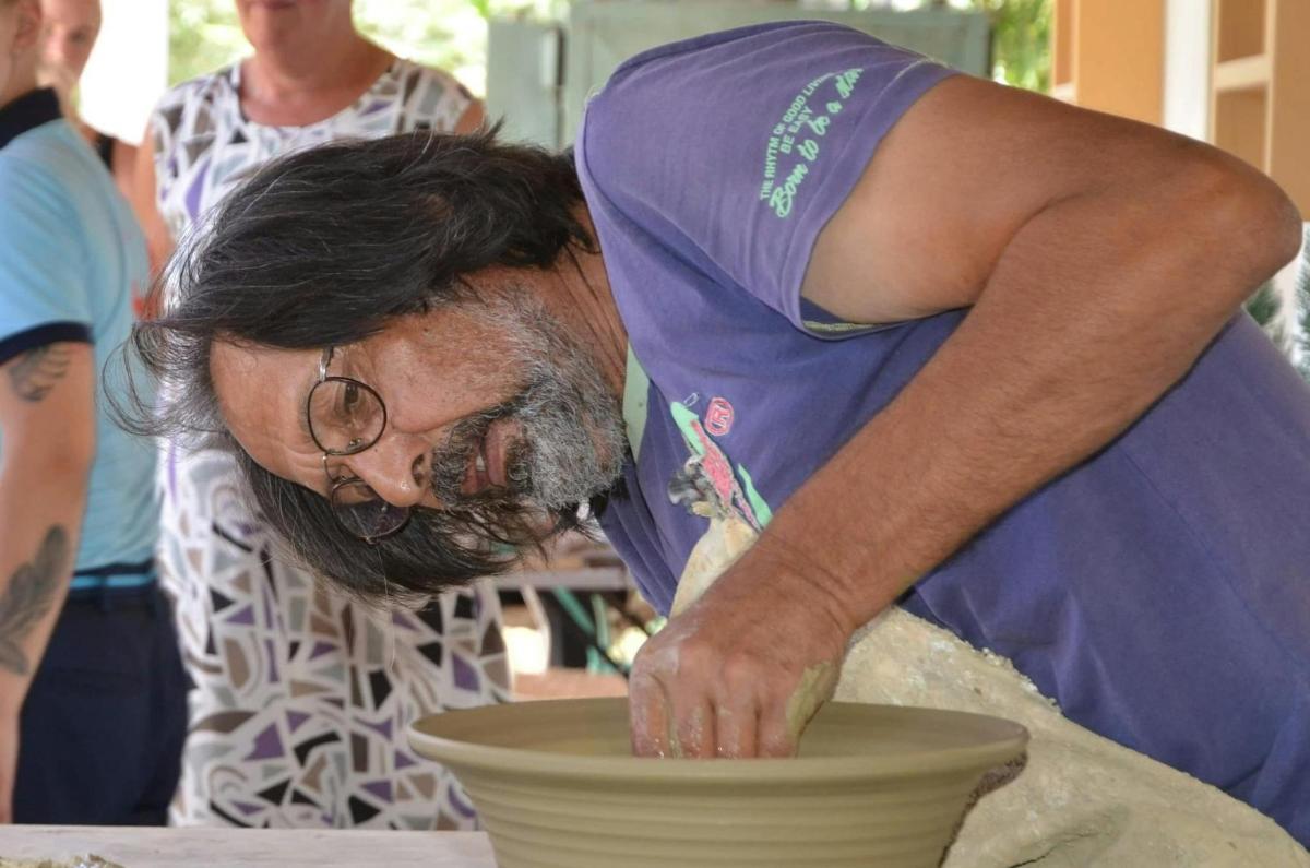 a man making a vase on a pottery wheel