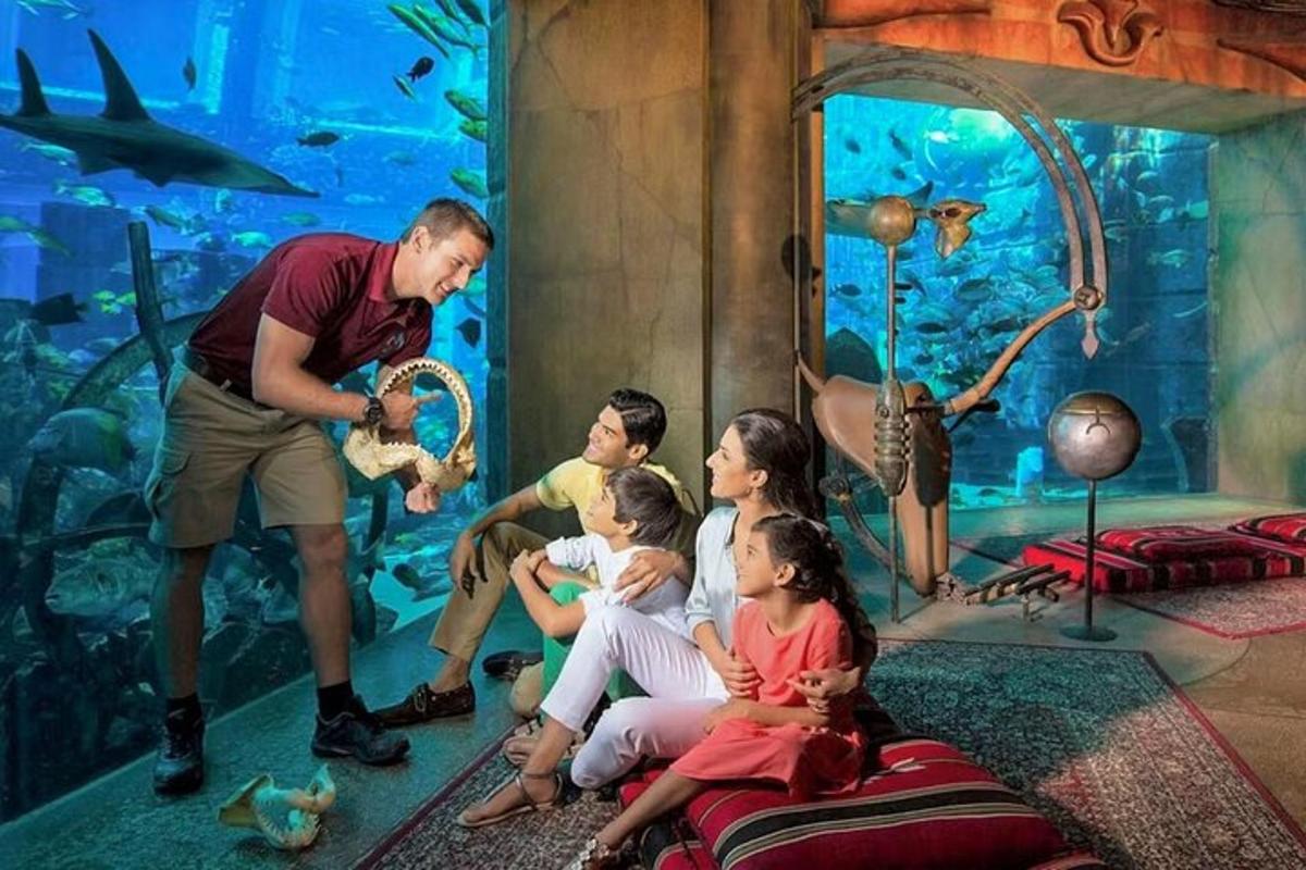 a family sitting in front of a large aquarium