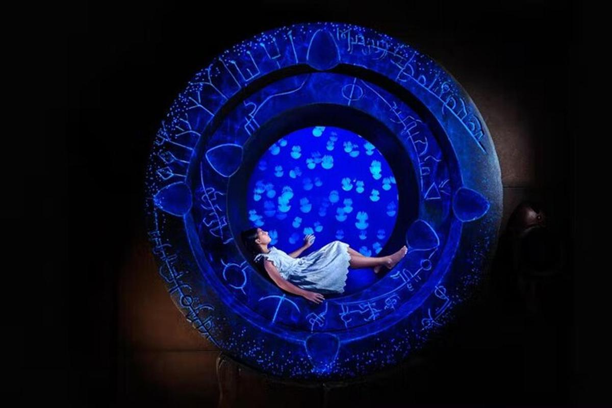 a woman is sitting in a blue glass window