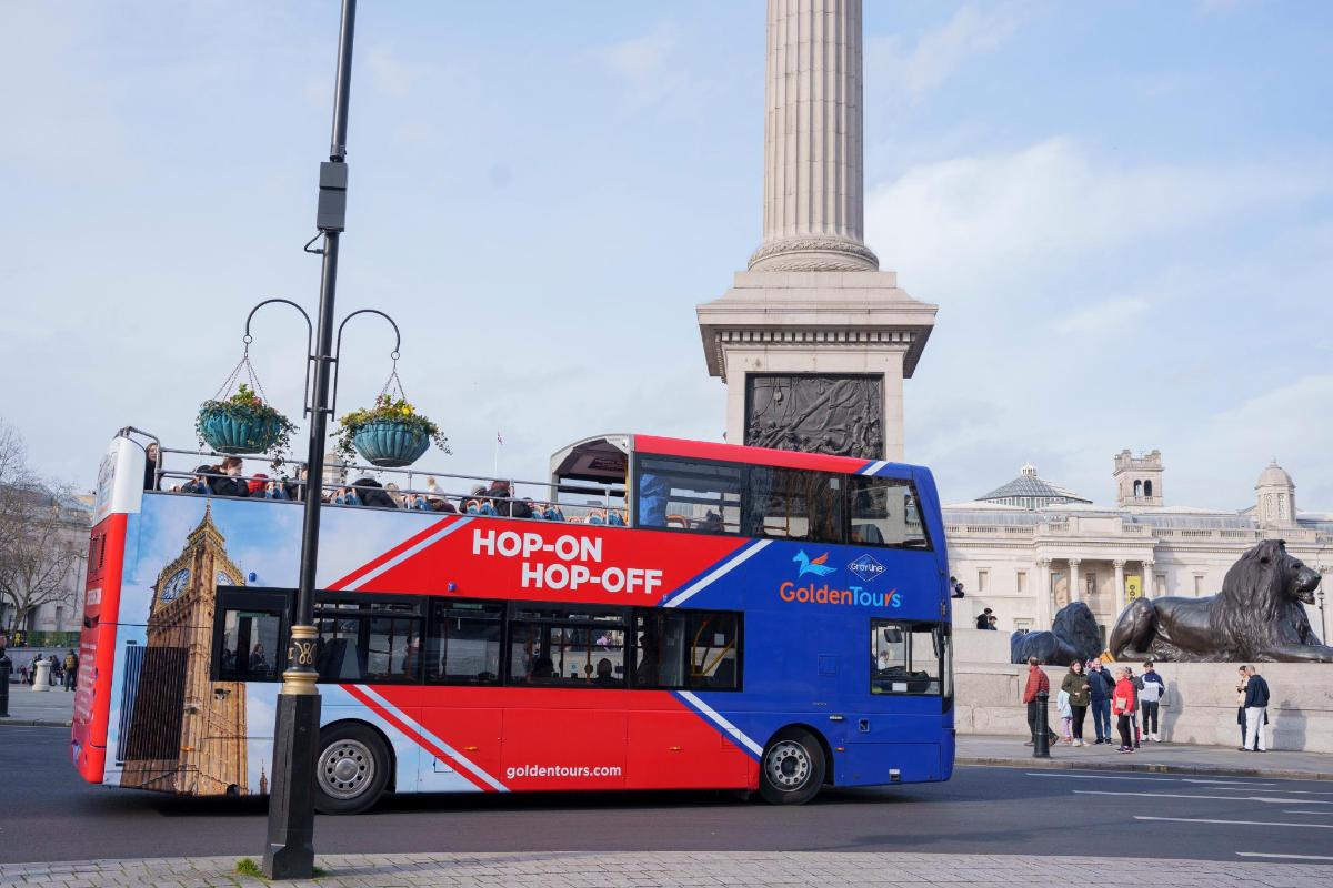 bas dua tingkat di hadapan monumen