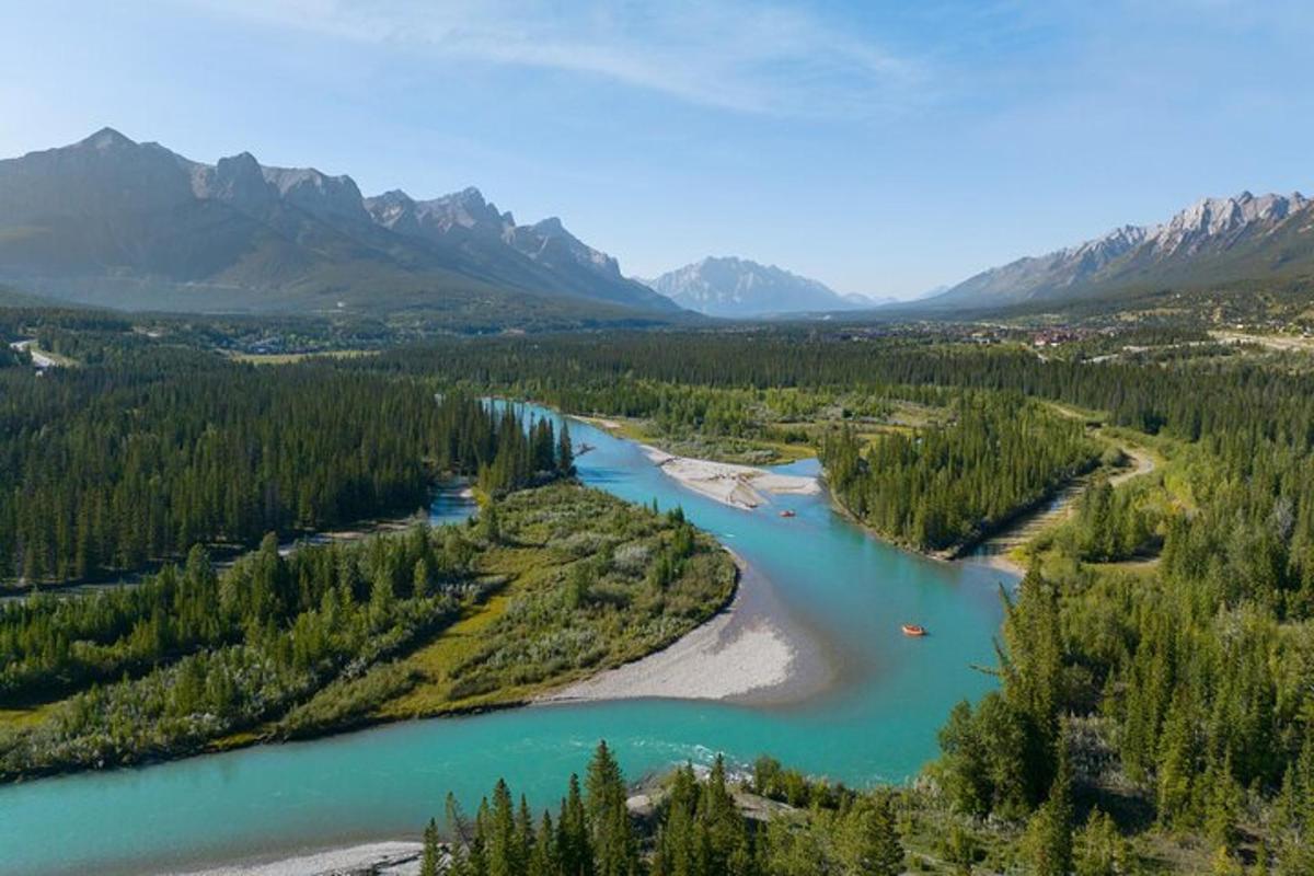 an aerial view of a river with trees and mountains
