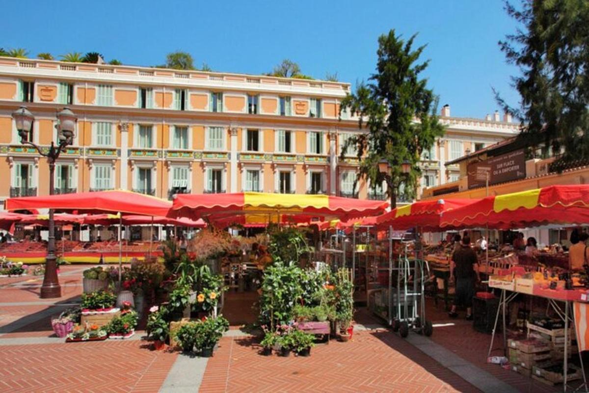 un mercat amb paraigües vermells i grocs i un edifici