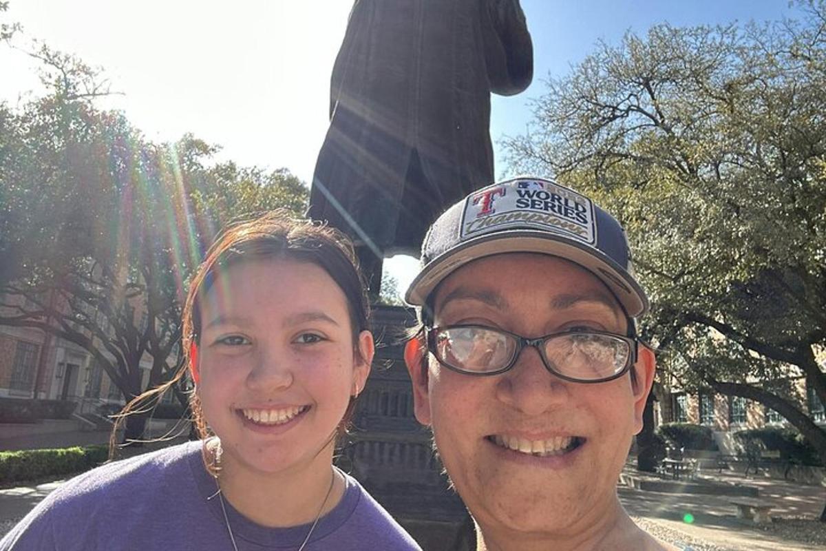 a man and a woman standing in front of a statue