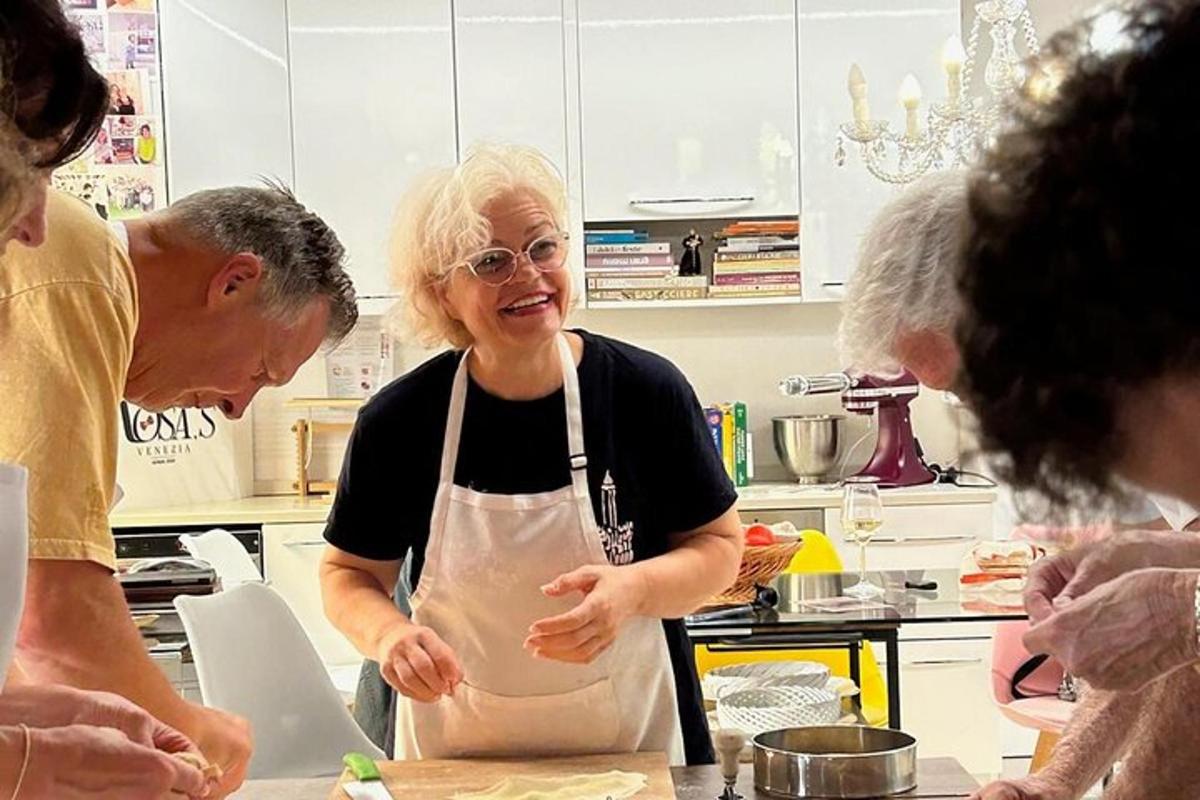 Una mujer en una cocina con un grupo de personas.