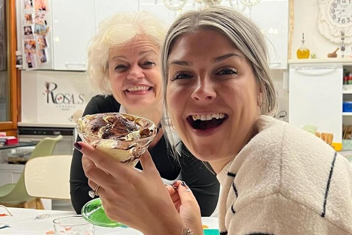 Dos mujeres sentadas en una mesa con un plato de comida.