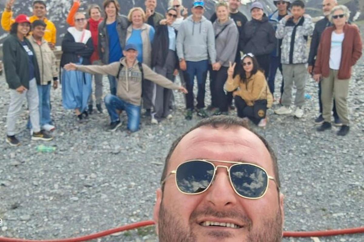 мъж, носещ слънчеви очила, пред група хора