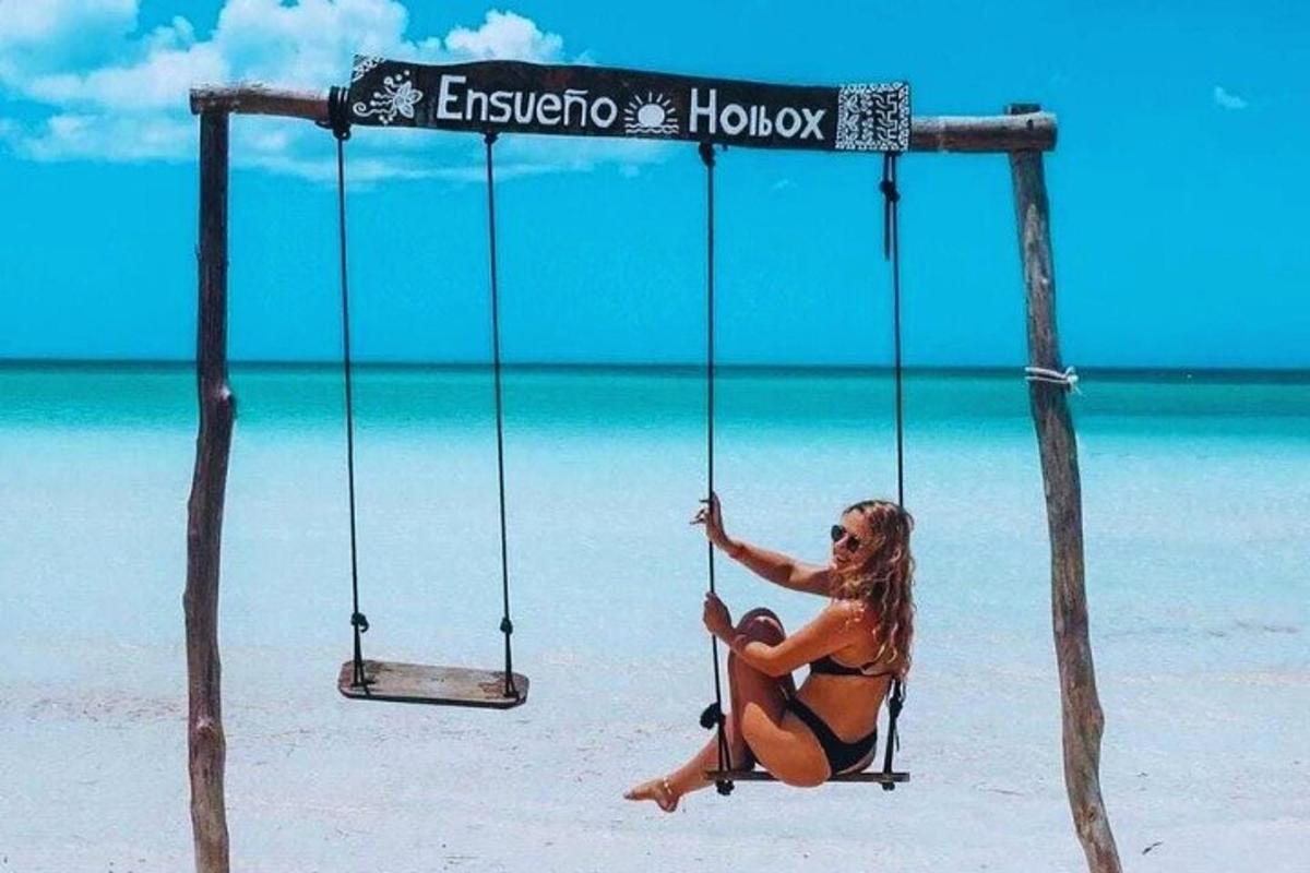 žena sedící na houpačce na pláži