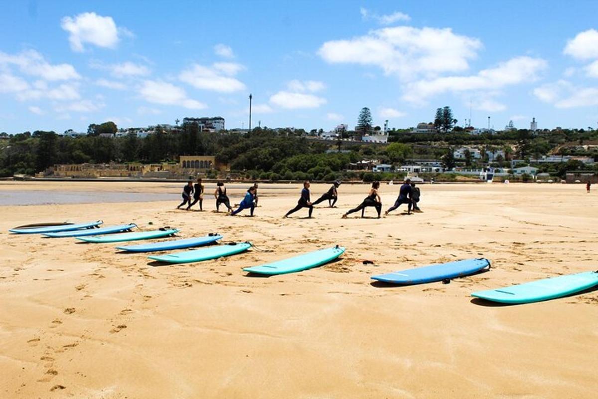 a group of people walking on the beach with surfboards