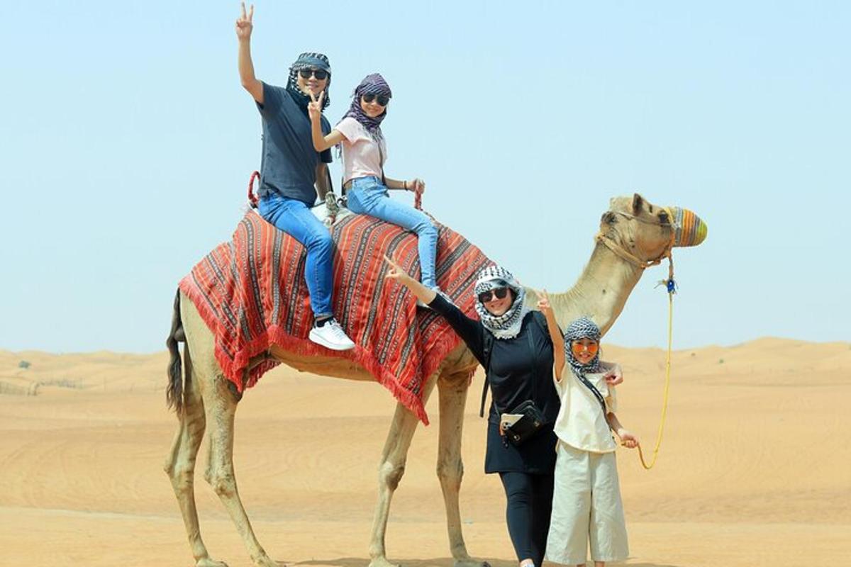 un gruppo di persone a cavallo di un cammello nel deserto