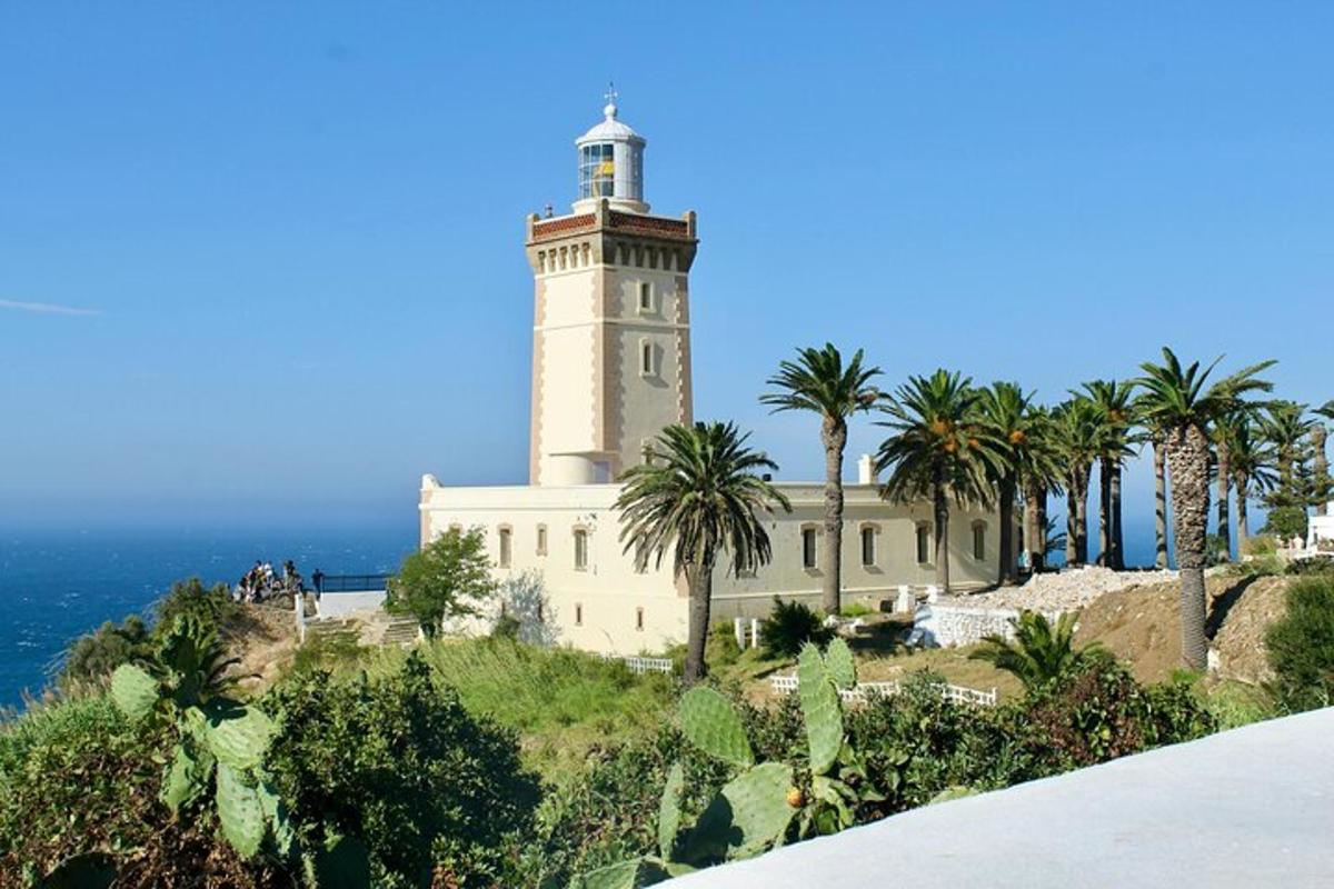 un faro in cima a una collina con palme