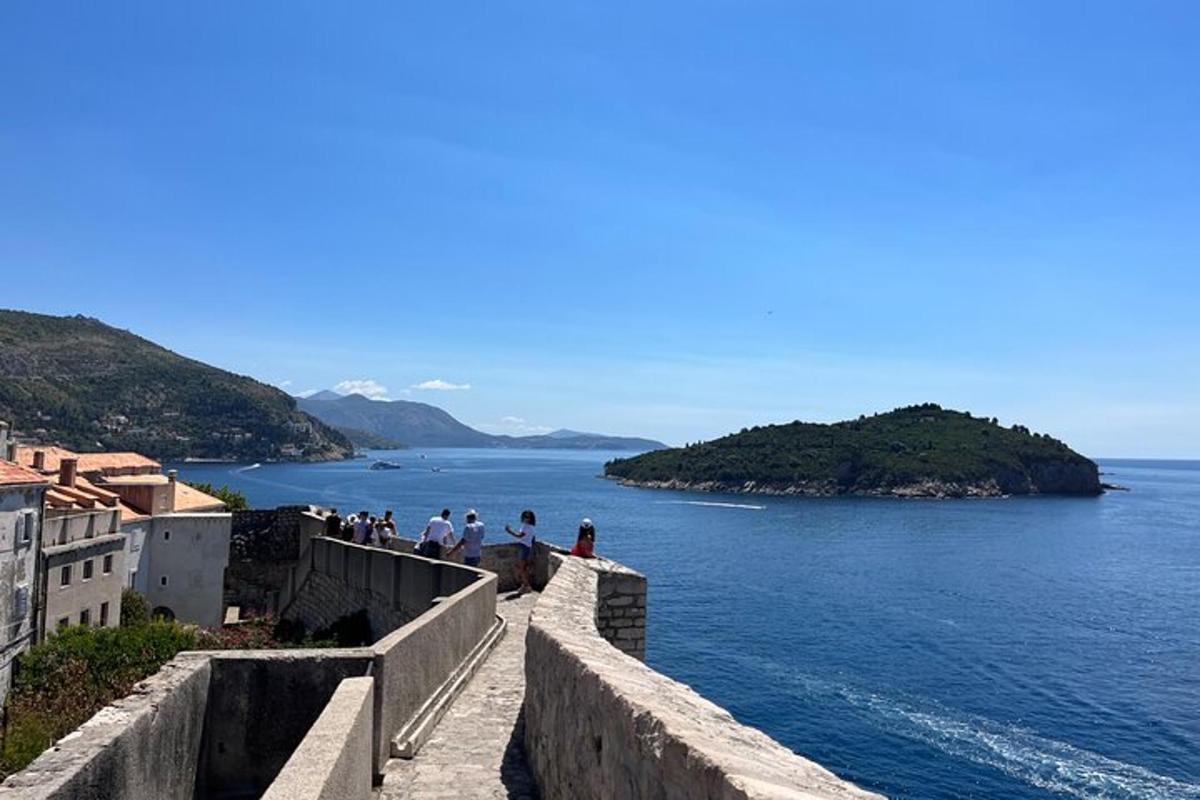 un gruppo di persone in piedi su un muro vicino all'acqua