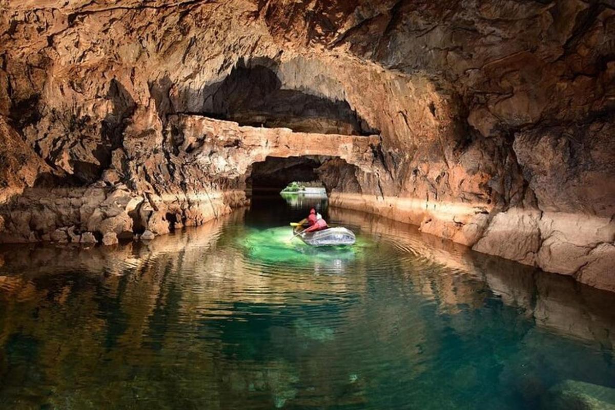 una persona en un bote en una cueva en el agua