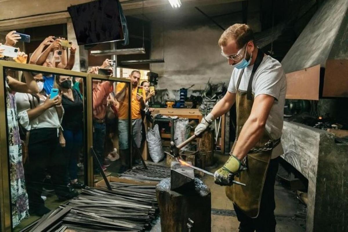 a man in a room with a sword in a forge