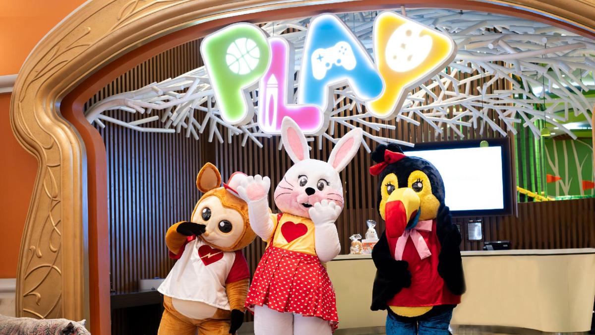 tiga haiwan boneka sedang berdiri di hadapan papan tanda