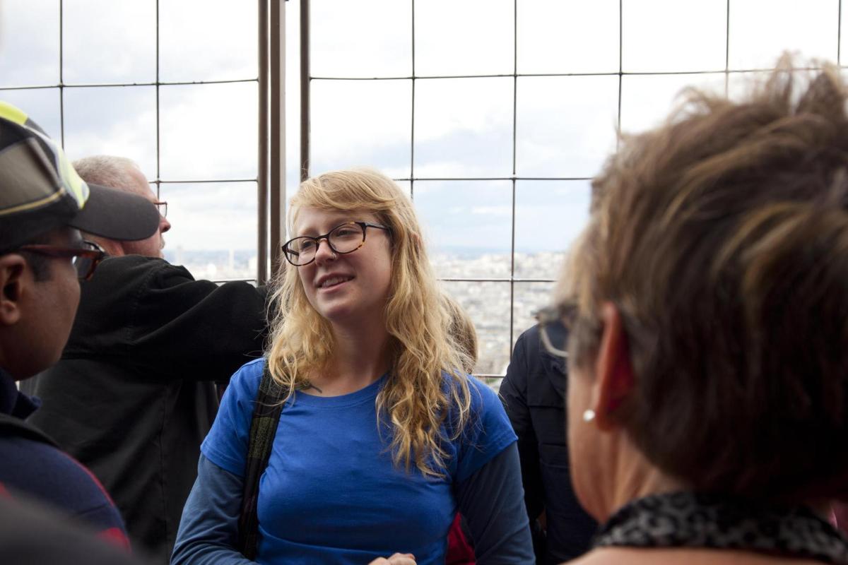 a woman with glasses sitting in a group of people
