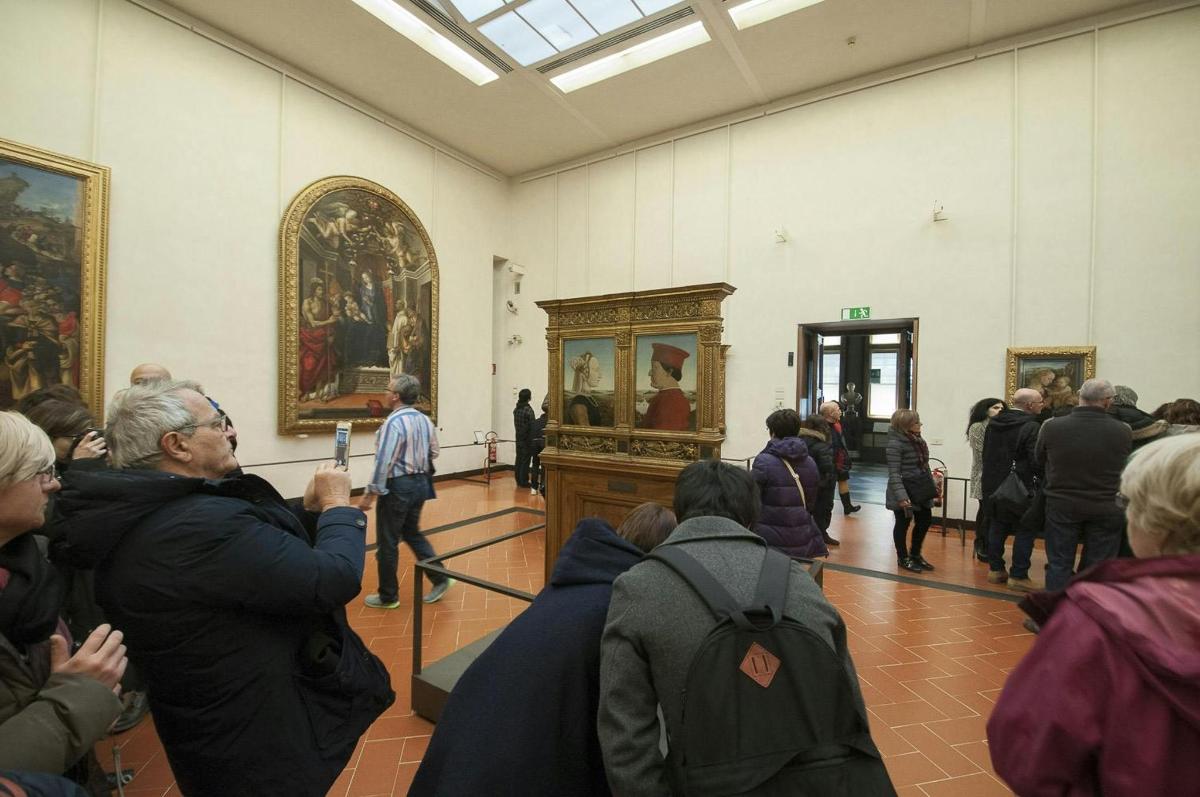 Un grupo de personas en un museo mirando pinturas.