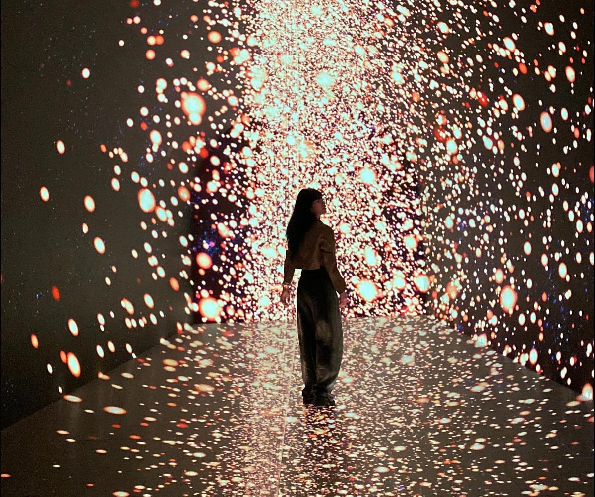 a woman standing in a tunnel of lights