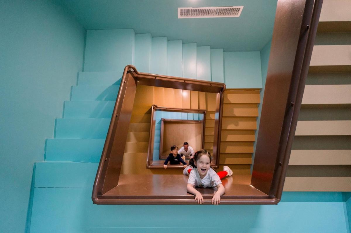 a little girl is sitting on a slide