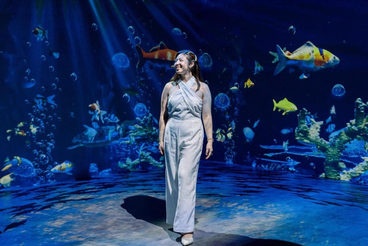 a woman standing in front of an aquarium