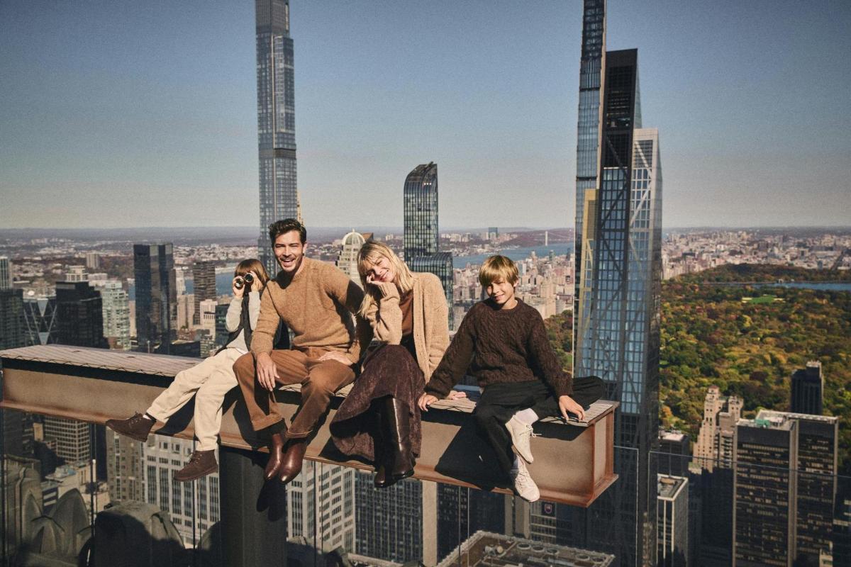a group of people sitting on the edge of a building