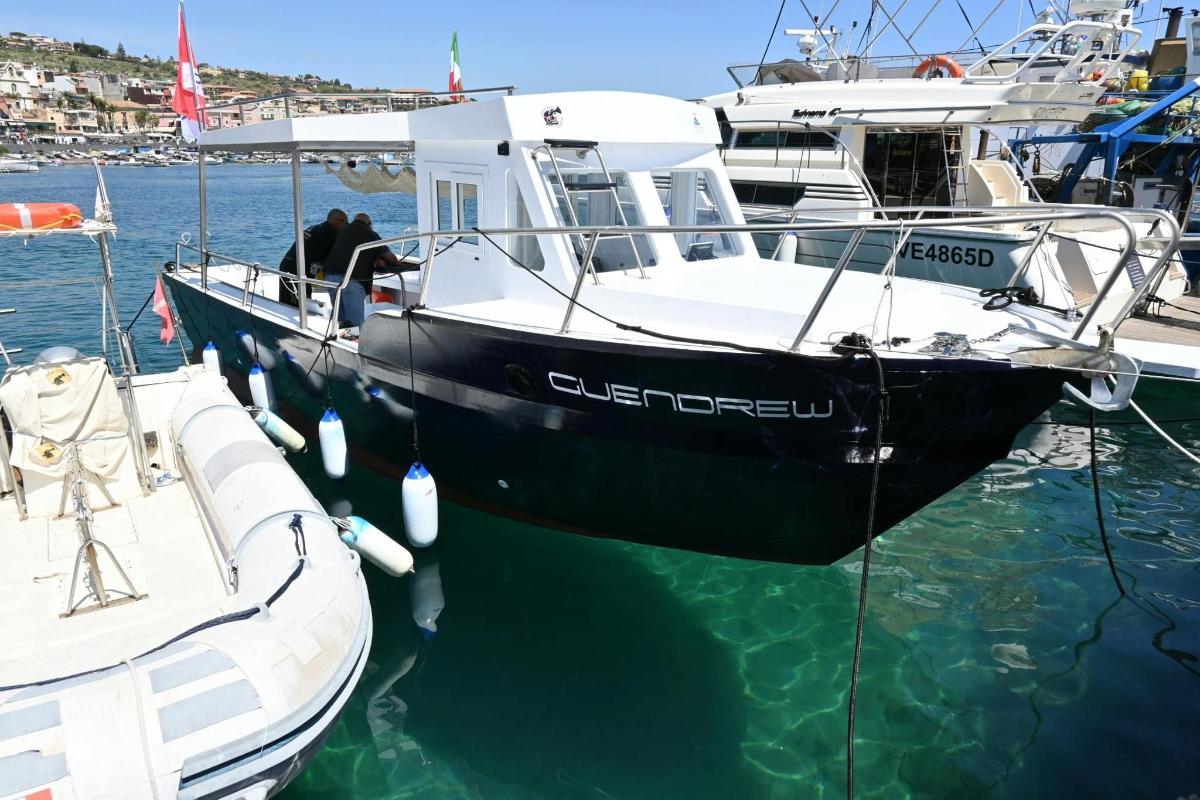 Un barco blanco y negro está atracado en el agua.