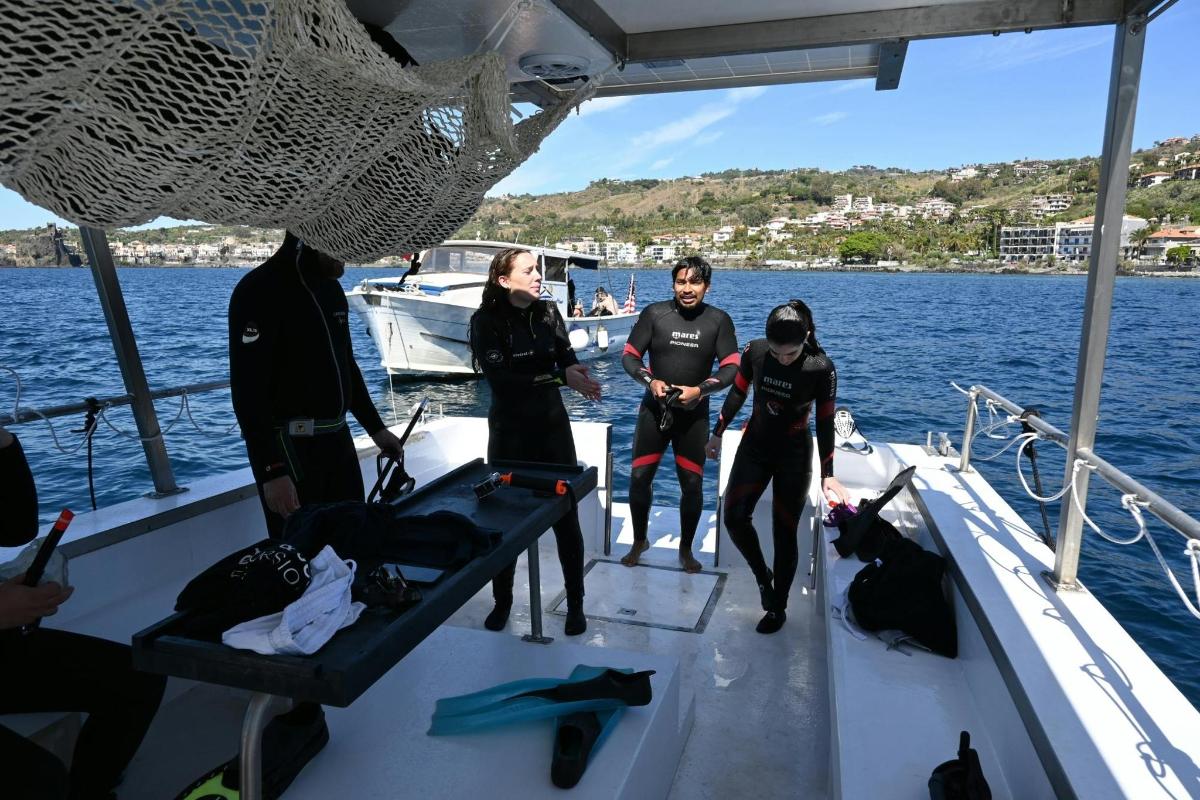 Un grupo de personas de pie en un bote en el agua.