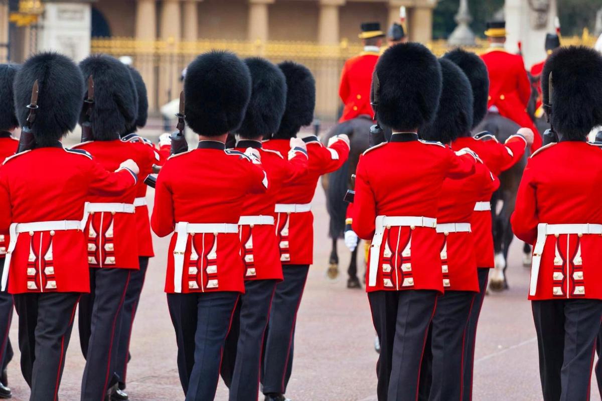 Un grupo de mujeres con uniformes rojos caminando por una calle.