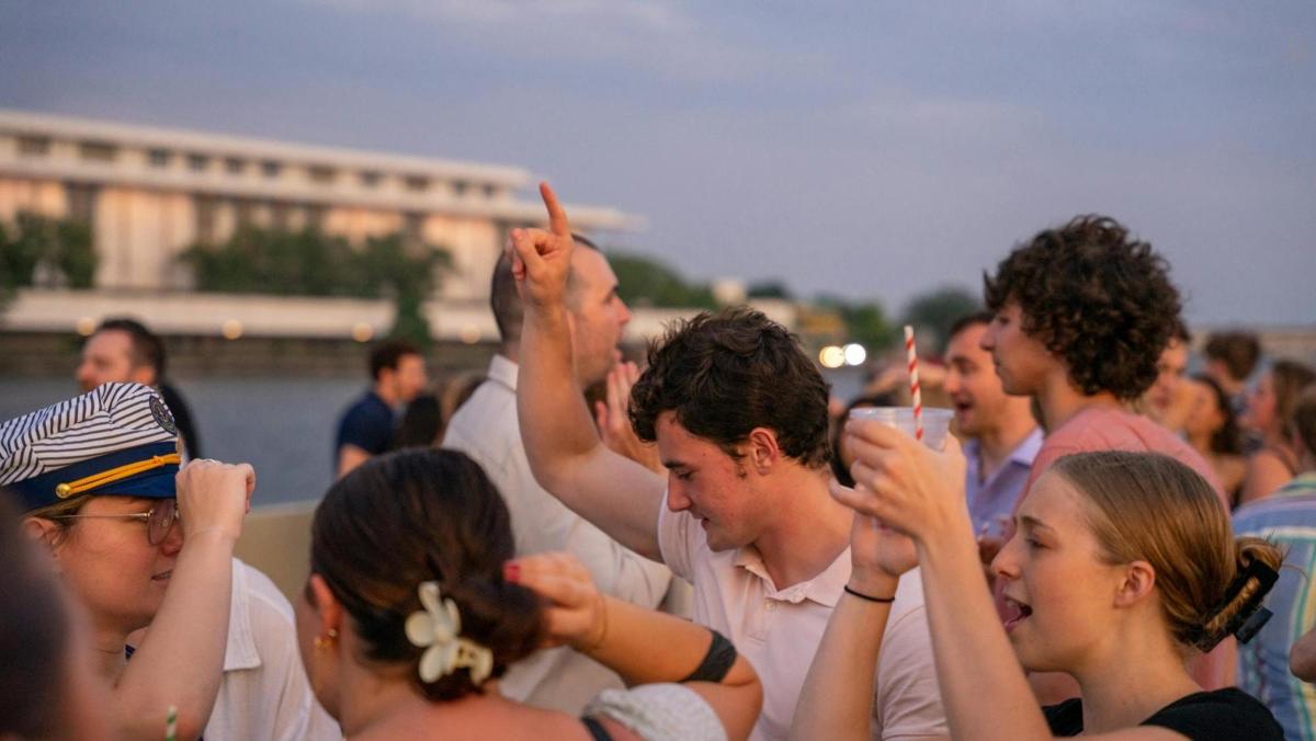 a group of people standing around with their hands in the air