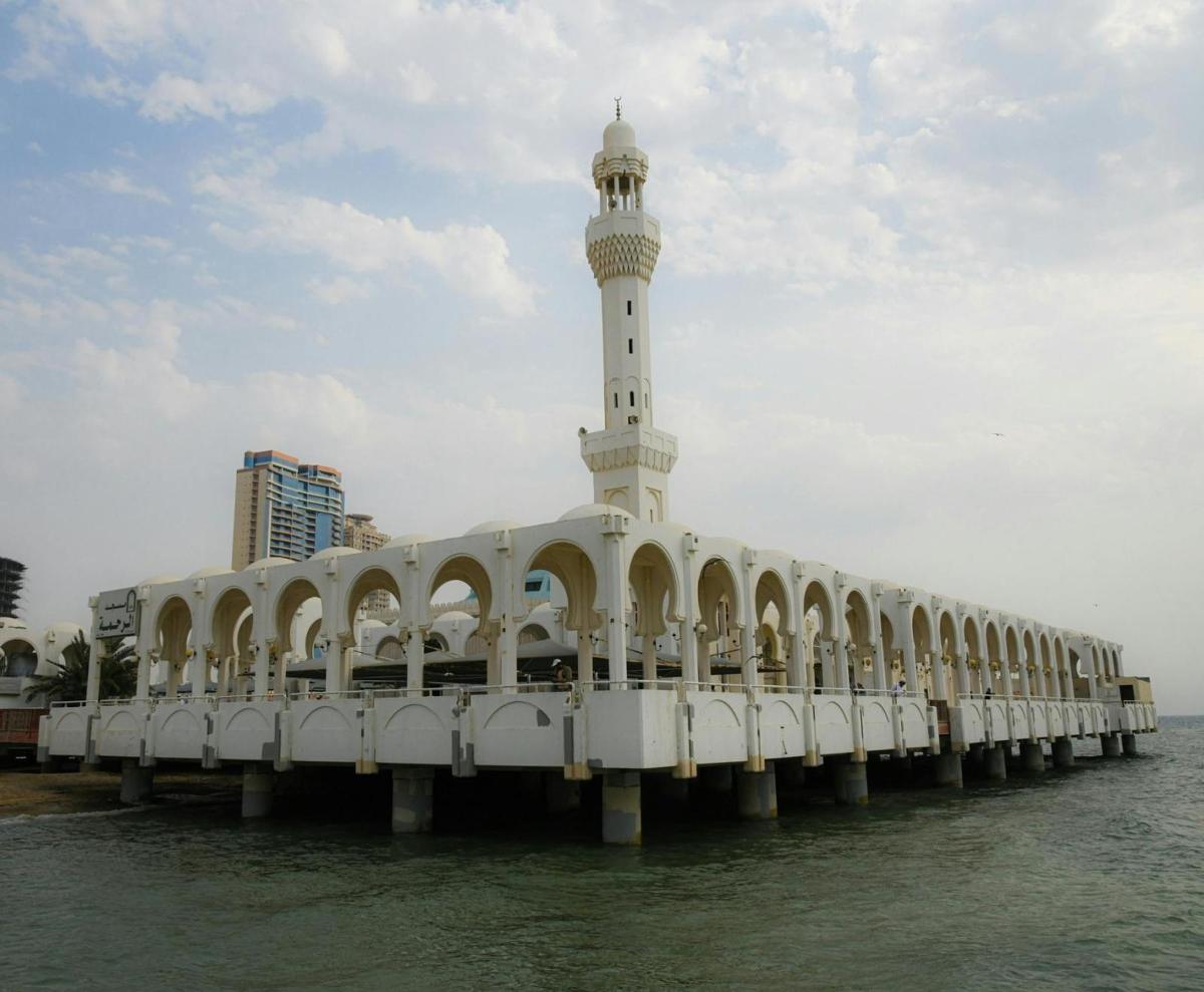 a building on the water with a clock tower on it